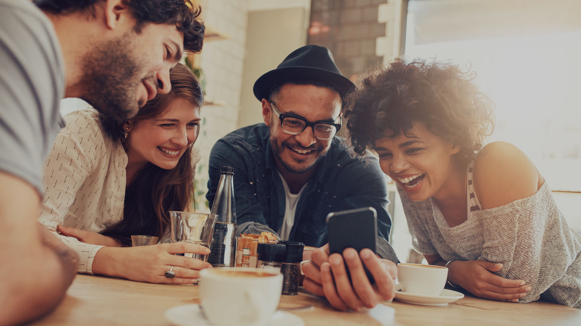 coverbild 4_menschen_im_kreis_schauen_auf_ein_handy
